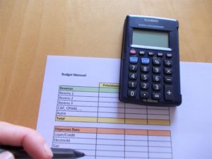 tableau budget, calculatrice, doigt et crayon